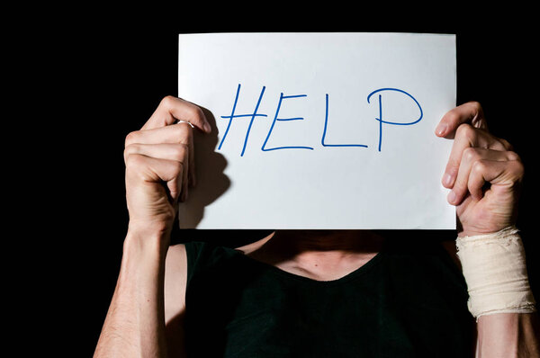 Mental ill suicidal depression man holding help sign paper after suicide attempt to cut his veins