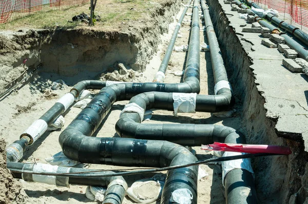 Bölge Isıtma sistemi boru hattı onarım ve yeniden yapılanma paralel borular ile yapı sitesi güvenlik ağı çitleri ile sokak.