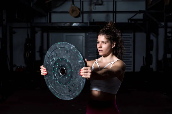 근육질의 근육질의 여자가 무거운 접시를 손으로 에서의 훈련을 하드코어 크로스 — 스톡 사진