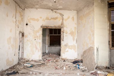 Terk edilmiş hasarlı ve yıkık dökük evlerin kalıntıları savaş bölgesinin seçici odak noktası olan çökmüş çatı ve duvar bombardımanlarıyla dolu.