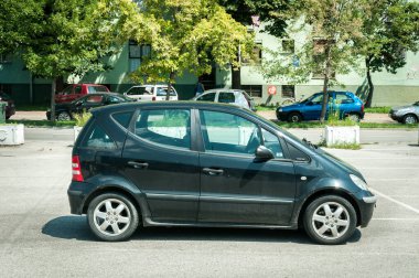 Yeni siyah Mercedes Benz A sınıfı araba şehirde sokağa park edilmiş.