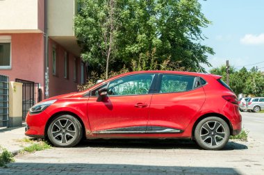 Novi Sad, Sırbistan. Temmuz - 31. 2018. Yeni kırmızı Renault Clio IV arabalı alaşımlı tekerlekler şehirde sokağa park edilmiş..