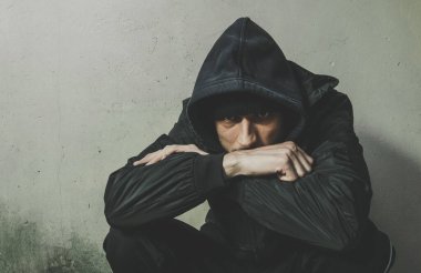 Evsiz adam, uyuşturucu ve alkol bağımlısı. Kışlık kıyafetleriyle sokakta yalnız başına oturuyor. Endişeli, soğuk ve yalnız, sosyal belgesel konsepti dramatik.