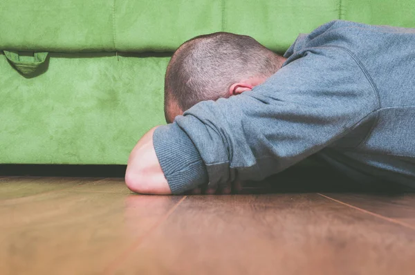 沮丧而孤独的男人脸朝下躺在他家的地板上哭泣 — 图库照片
