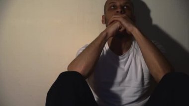 Yalnız ve bunalımlı bağımlı bir adam karanlık evinde yerde tek başına oturuyor sefil ve kaygılı karanlık görüntüler çekiyor sosyal sağlık hizmetleri konsepti