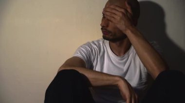 Yalnız ve bunalımlı bağımlı bir adam karanlık evinde yerde tek başına oturuyor sefil ve kaygılı karanlık görüntüler çekiyor sosyal sağlık hizmetleri konsepti