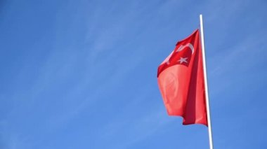 Türk Bayrağı ya da Türkiye mavi gökyüzü arka planında rüzgarda dalgalanıyor
