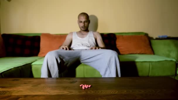 自殺うつ病に苦しんでいるうつ病男は 過剰摂取によって自殺したい強い薬や薬を服用痛みキラー彼の暗い部屋に座って選択的なフォーカスムーディー劇的な外観 — ストック動画
