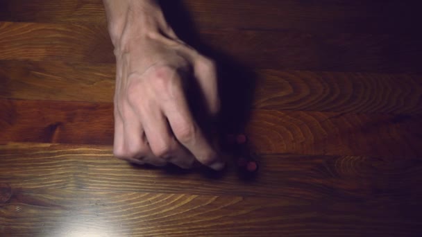 うつ病に苦しんでいるうつ病の人の手は 木製のテーブルヘルスケアの概念に彼の手で遊んで強力な薬や薬を服用することによって自殺したい — ストック動画
