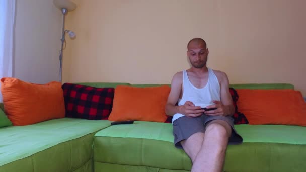 Młody Zabawny Bezrobotny Samotny Mężczyzna Szuka Zdjęć Dziewczyn Smartfonie Lub — Wideo stockowe