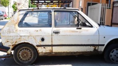 Novi Sad, Sırbistan. Nisan - 17. 2019. Eski hasarlı ve paslı Yugoslav Zastava Yugo arabası. Yazı