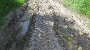 Çamurda ve çamurda tekerlek üstüne tekerlek izleri. Toprak taşıyıcı ya da buldozer inşaat kazıcı makineleri. Şehir caddesinde yapılan işi bitirir. 