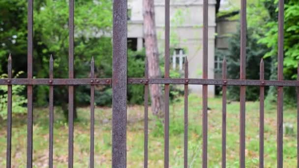 旧的坚固生锈的铁栅栏保护废弃的带金属格栅的别墅 — 图库视频影像