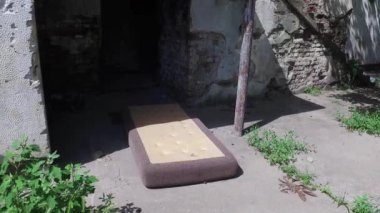 Evsizler için barınak olarak kullanılan döşekli yıkılmış eski bir ev. 