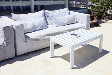 Bir yazlık tatil beldesinde beyaz kanepeile teras salonu .