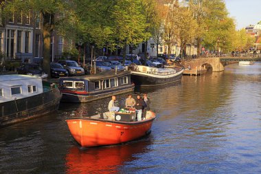 Arkadaş Amsterdam kanallarında tekne sürüş keyfini çıkarın