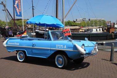 amphibian vehicle is parked along the canal in Amsterdam, Netherlands clipart