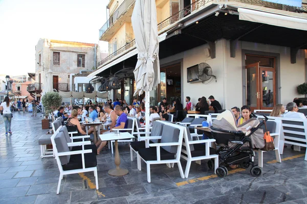 La gente se sienta en la acera café de la calle en Rethymno frente al mar, Creta — Foto de Stock