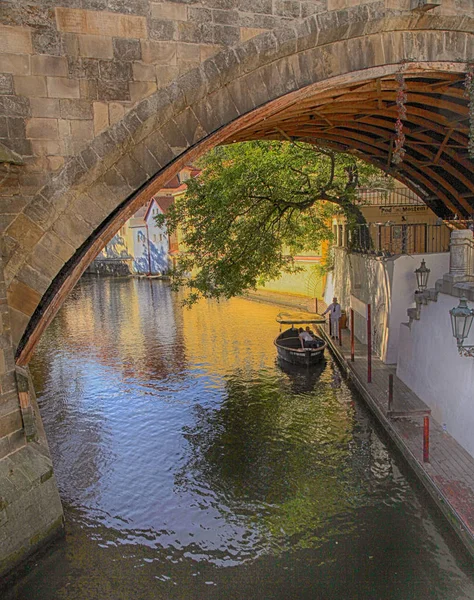 Båt och gamla hus under Karlsbron i den smala floden djävulen, Prag — Stockfoto