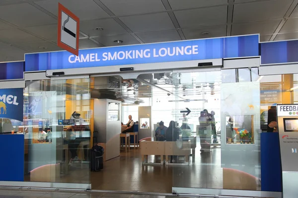 Зал для курящих верблюдов с пассажирами в международном аэропорту Мюнхена — стоковое фото