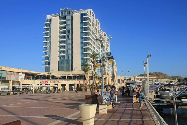Turistas en el paseo marítimo y el hotel Ritz-Carlton Herzliya en su —  Fotos de Stock