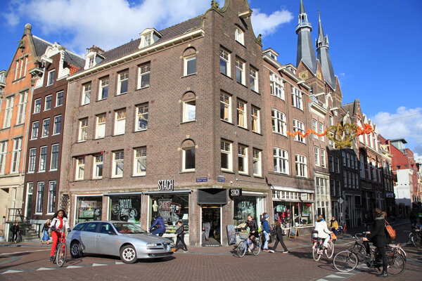 AMSTERDAM, NETHERLANDS - MAY 3,2016: A typical Amsterdam street (Haarlemmerstraat) with old dutch buildings, cyclists and cafe in Old Town of Amsterdam, Netherlands.