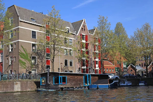 Edificios holandeses y casa flotante a lo largo del canal, Amsterdam — Foto de Stock