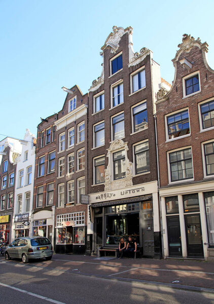 AMSTERDAM, NETHERLANDS - MAY 8, 2016: Traditional brick buildings on street in historical center in Amsterdam, the Netherlands.