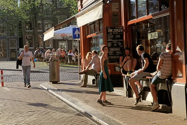 Young people in outdoor cafe in historic center of Amsterdam — Stock Photo, Image