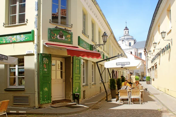 Mensen ontspannen in outdoor sidewalk café in de oude stad, Vilnius, — Stockfoto