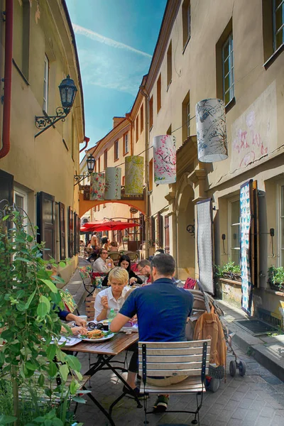 La gente mangia e beve al caffè marciapiede nel centro storico o — Foto Stock