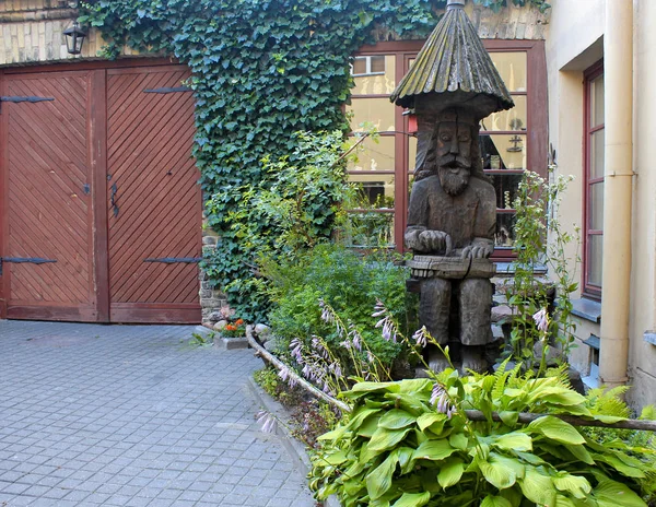 Escultura tradicional lituana tallada en madera en un pequeño patio verde —  Fotos de Stock