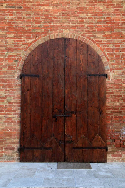 Puerta de madera antigua en casa de ladrillo, Italia —  Fotos de Stock