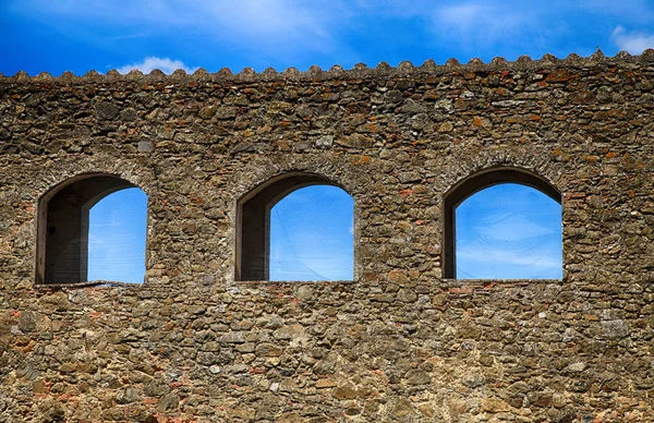 Íves ablakok tönkre kőfal ellen a kék eget, Olaszország — Stock Fotó