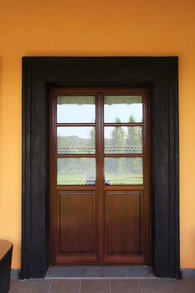 Venkovské italské dům s dřevěnými dveřmi a oranžové stěny — Stock fotografie