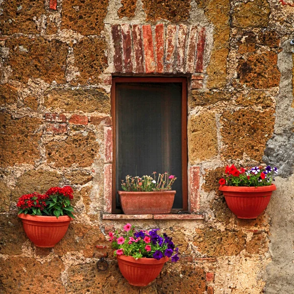 Janela italiana pequena com flores agradáveis, Itália — Fotografia de Stock