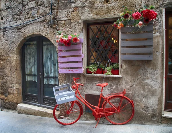 Red bike in a traditional Italian medieval town, Tuscany, Italy. — Stock Photo, Image