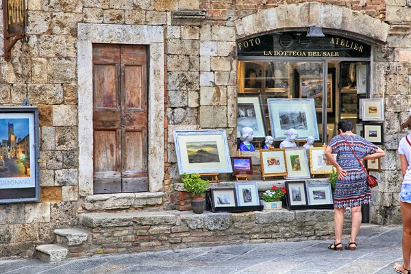 Turistas en la tienda de regalos en la ciudad medieval de San Gimignano, Italia —  Fotos de Stock