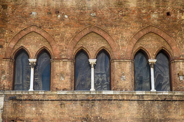 Fereastră arc la clădirea medievală din cărămidă în centrul istoric al Sienei — Fotografie, imagine de stoc