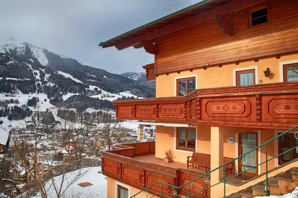 Casa alpina con balcón de madera en invierno pueblo de montaña, Alpes —  Fotos de Stock