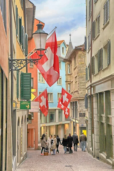 Люди на пешеходной улице с флагами на старых зданиях в Цюрихе — стоковое фото