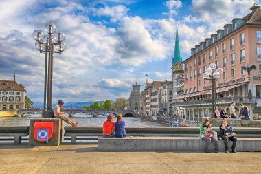 Oturan insanlar ve nehir Limmat, Zürih, İsviçre köprüde rahatla.
