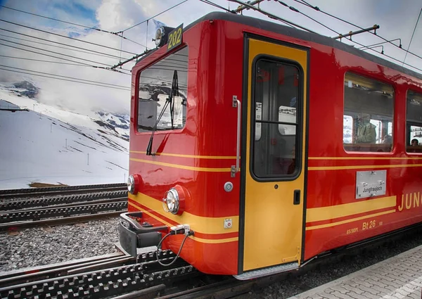 Železniční stanice s červenými švýcarský vlak a hory Jungfrau, Švýcarsko. — Stock fotografie