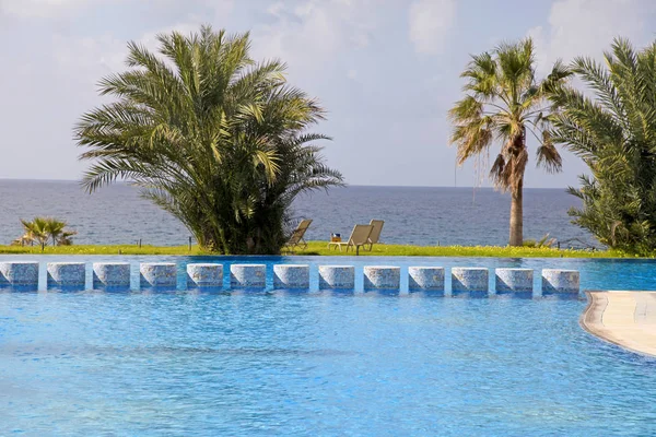 Palmbomen, zwembad en prachtig uitzicht op zee — Stockfoto