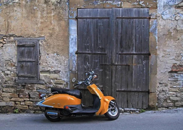 Strada nel centro storico con porta in legno e vecchio scooter — Foto Stock