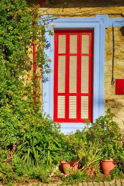 Bela janela azul e vermelho na casa da aldeia mediterrânea — Fotografia de Stock