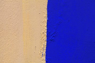 Duvar eski sarı ve mavi renklerde boyanmış. Sarı ve mavi renklerle boyalı grunge sıva duvar dokulu arka plan 