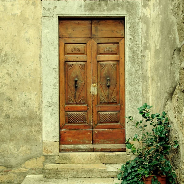 Oude verweerde houten deur van dorp house, Toscane, Italië. — Stockfoto