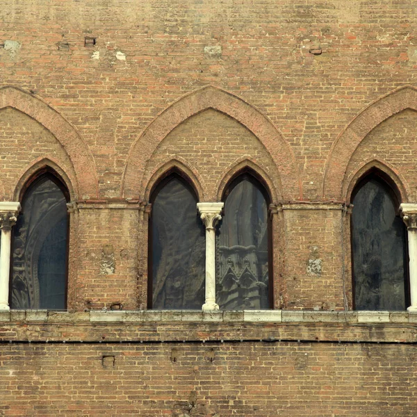 Арочное окно в средневековом кирпичном здании, Сиена, Италия — стоковое фото