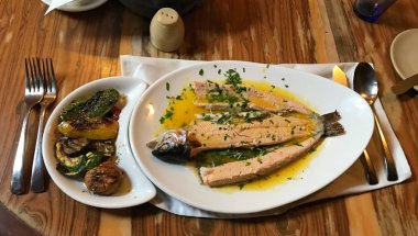 Kızarmış alabalık ahşap masanın üzerine sos ve dereotu ot ile. 